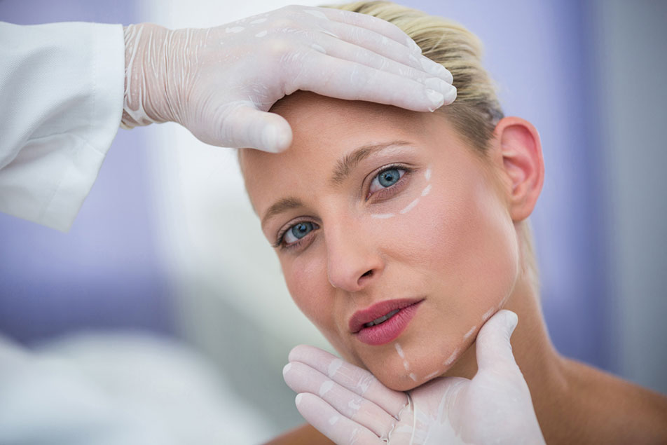 Doctor examning female face treatment areas