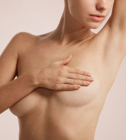 Woman covering her breasts with her hand