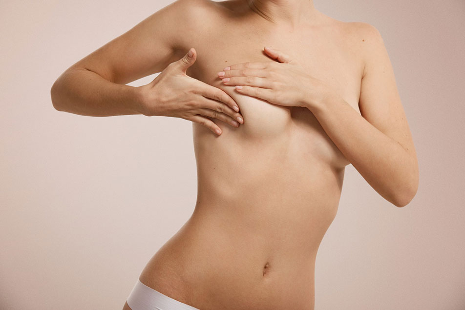 Woman checking her breasts after augmentation surgery
