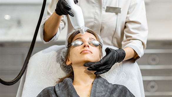 Woman in gray robe getting halo laser treatment
