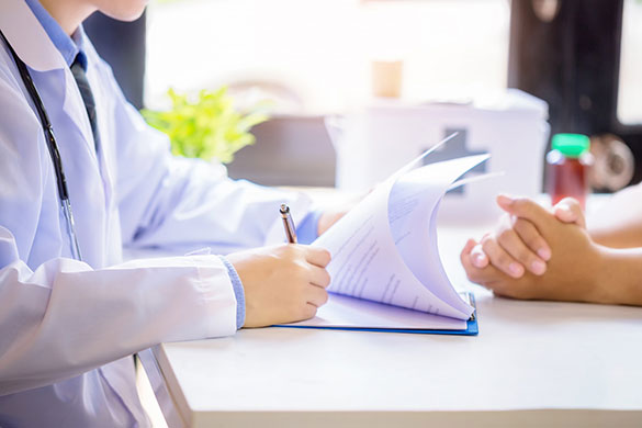 Doctor filling up documents during consultation with patient