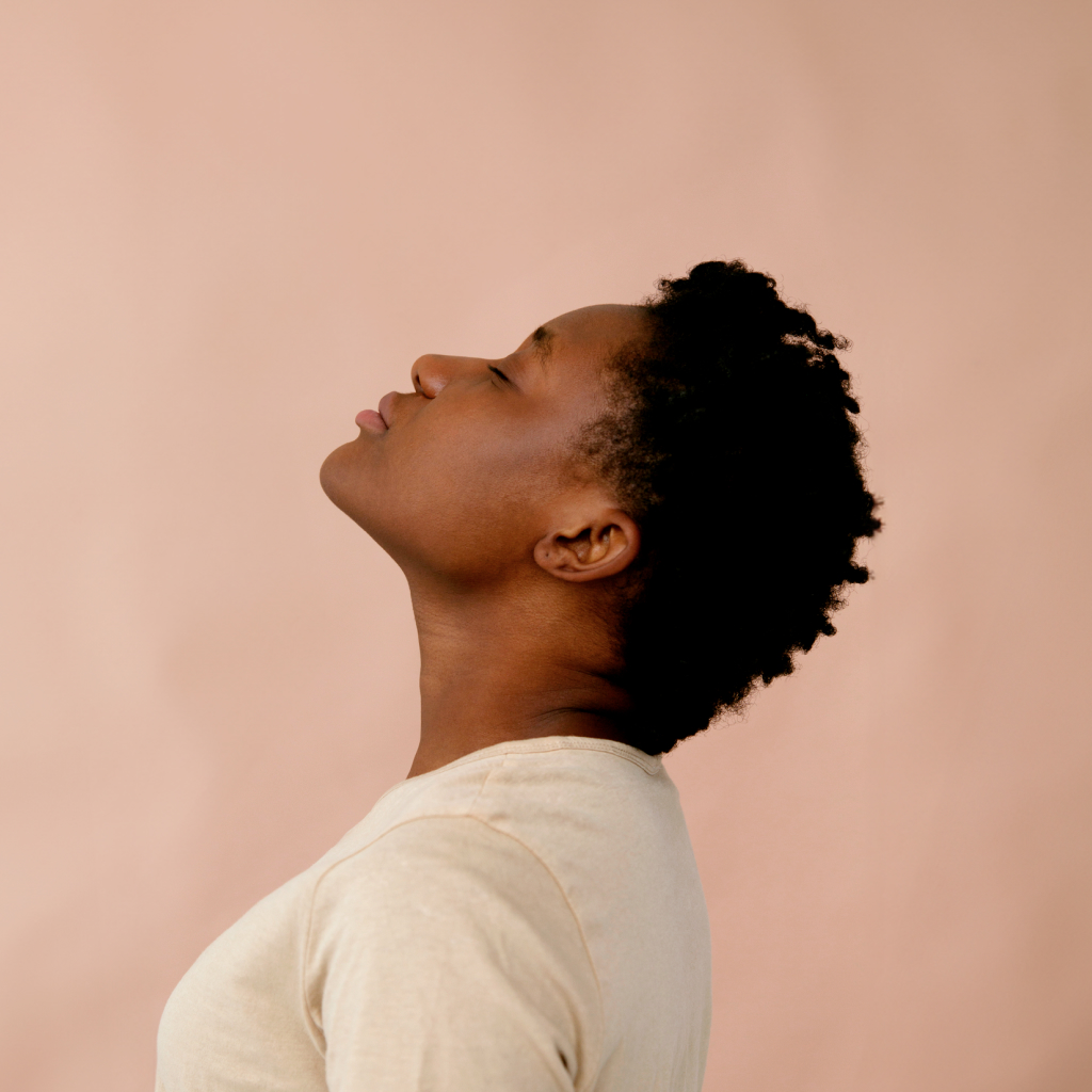 women looking up wearing a white shirt on a pink background