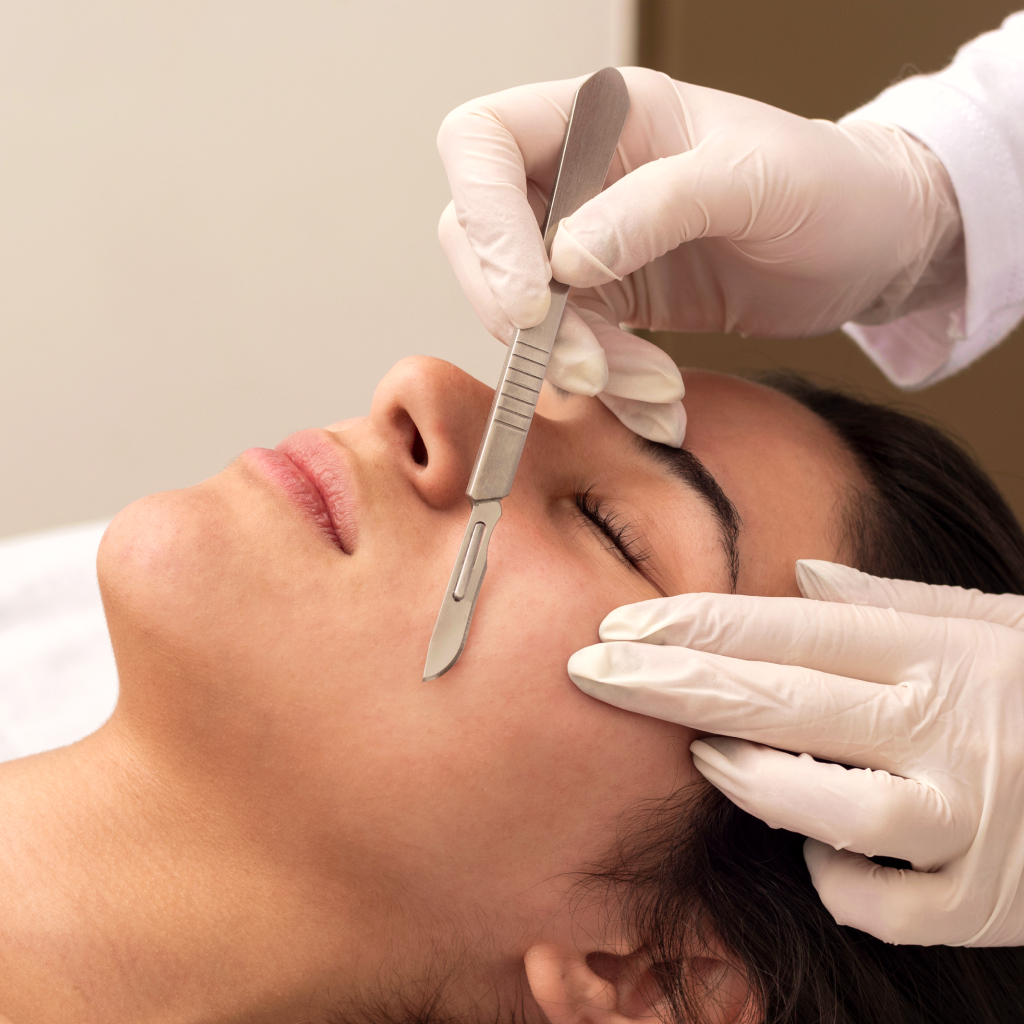 women laying on table, with a derma scalpel exfoliating skin