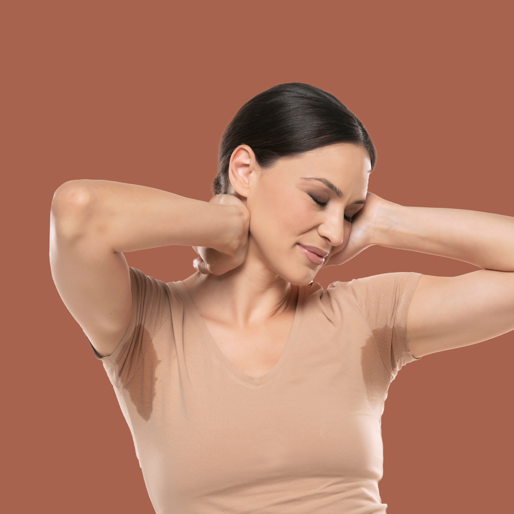women wearing a beighe shirt with arms exposing underarm sweat stains
