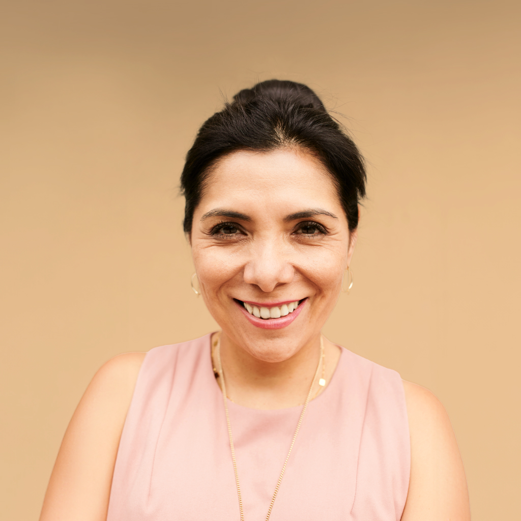women on smiling with visible wrinkles smiling against beige background