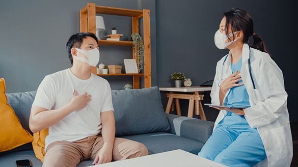 Man consulting doctor on a couch, both wearing masks