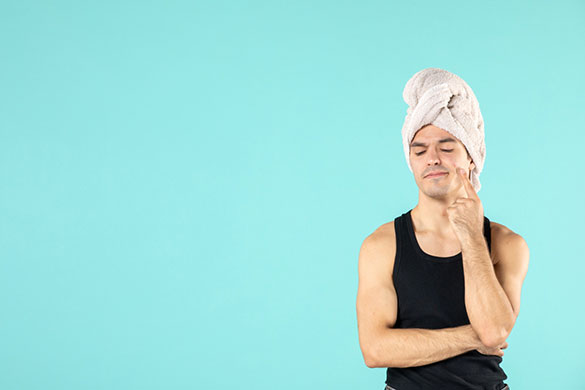 Man pointing out pimple on face