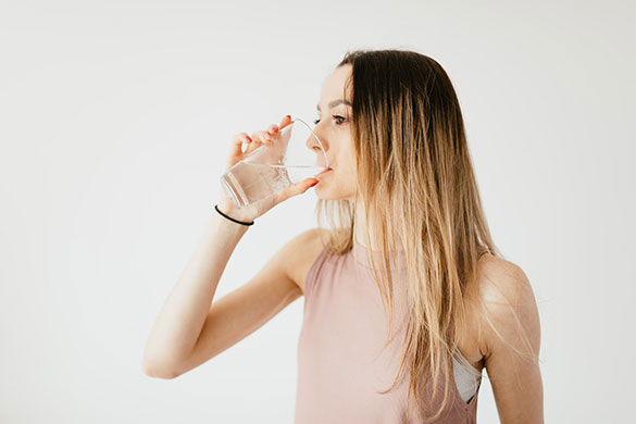 Woman drinking water from clear glass